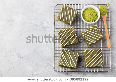 Stok fotoğraf: Matcha Green Tea Brownie Cake With White Chocolate On A Cooling Rack Grey Stone Background Top View