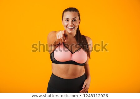 Foto stock: Portrait Of Pretty Chubby Woman In Sportive Bra Smiling And Stan