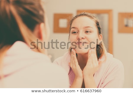 Stockfoto: Woman In Bathroom Take Care Of Her Skin With Cosmetics