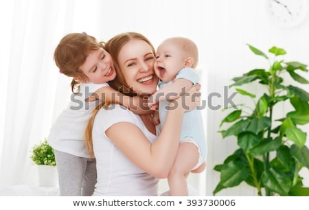 Foto d'archivio: Mother And Two Children In The Bedroom On The Bed