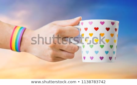 Foto stock: Hand With Cup Of Cacao And Gay Awareness Wristband