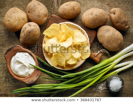 Stockfoto: Fresh Organic Homemade Potato Crisps Chips With Sour Cream And Red Onions On Chopping Board On Dark