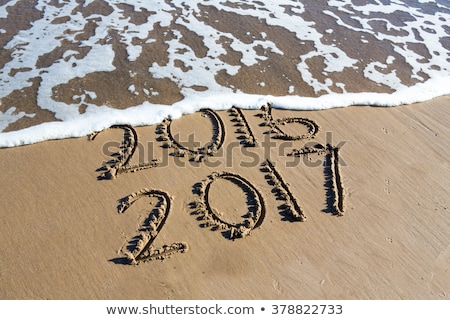 Stockfoto: New Year 2017 Is Coming Concept - Inscription 2016 And 2017 On A Beach Sand The Wave Is Almost Cove
