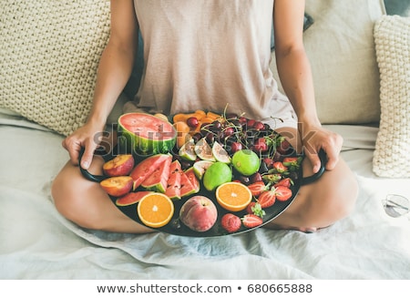 Сток-фото: Woman On Bed Eating Fruit