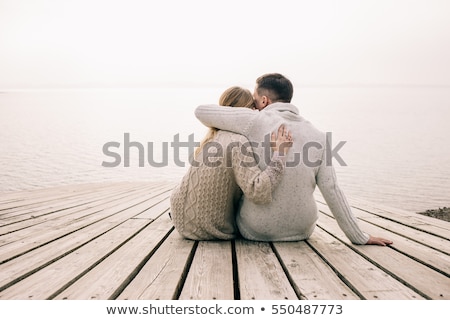 Zdjęcia stock: Loving Couple Sitting On The Pier On Lake