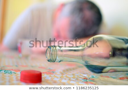 商業照片: Drunk Man Lying On A Counter With Bottle Of Whisky