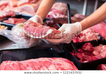 Meat In A Butcher Shop Display Being Put In By Sales Woman Foto d'archivio © Kzenon