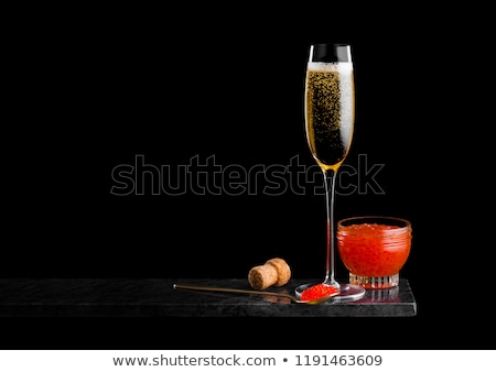 Stockfoto: Elegant Glass Of Yellow Champagne With Red Caviar On Golden Spoon And Glass Container Of Caviar On M