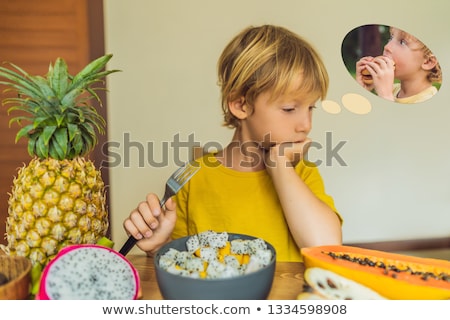 Foto stock: Boy Eats Fruit But Dreams About Hamburger Harmful And Healthy Food For Children Child Eating Healt