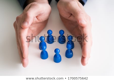 Foto stock: Person Protecting Multicolored Pawns
