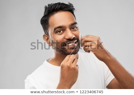 Stok fotoğraf: Indian Man With Dental Floss Cleaning Teeth