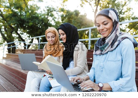 Stock fotó: Photo Of Three Cheerful Women Wearing Headscarfs Sitting On Bla