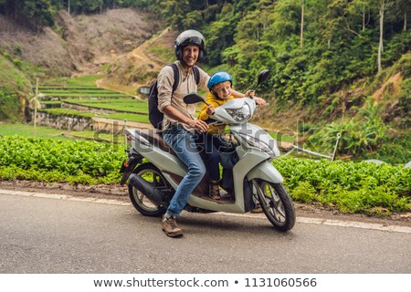 Foto stock: Father And Son Are Traveling On A Moped On A Tea Plantation In Malaysia Traveling With Children Con