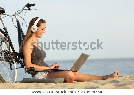 Foto d'archivio: A Young Girl Sits On The Beach Leaning