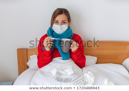 Stock photo: Woman Contracted Covid 19 Measuring Fever In Bed