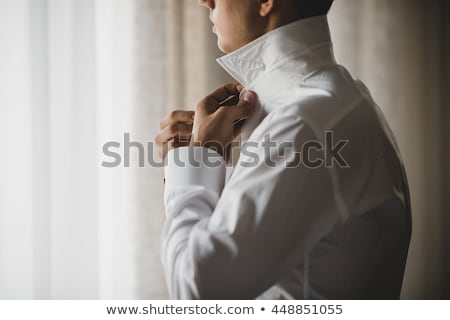 Foto stock: Young Man Buttons His White Shirt