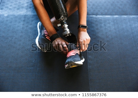 Stock photo: Strong Disabled Sports Woman Tie Her Laces In Gym
