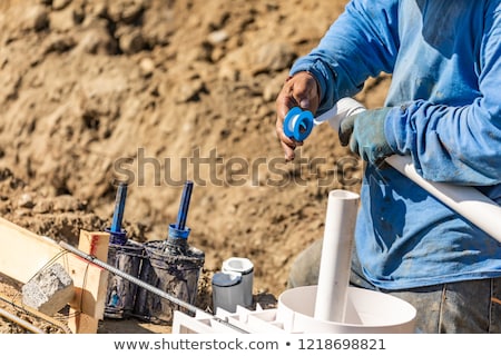 Foto stock: Plumber Applying Ptfe Tape To Pvc Pipe At Construction Site