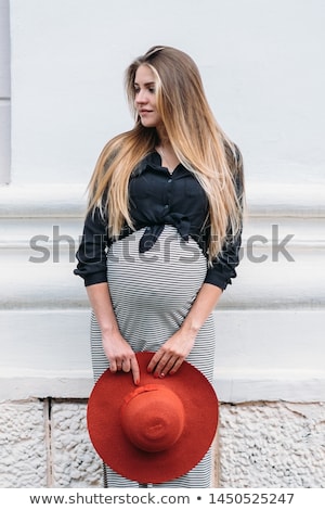 Imagine de stoc: Beautiful Pregnant Woman With Blond Hair In Long Red Dress And Shiny Necklace Is Standing In The For