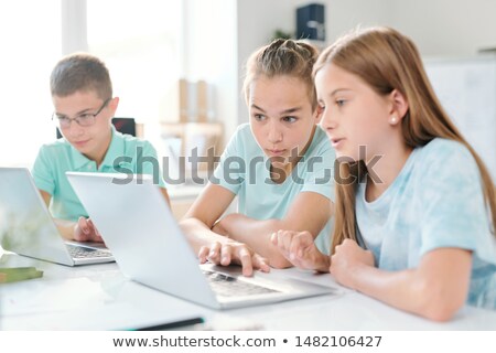 Middle School Boy And Girl Looking At Curious Stuff On Laptop Display Сток-фото © Pressmaster