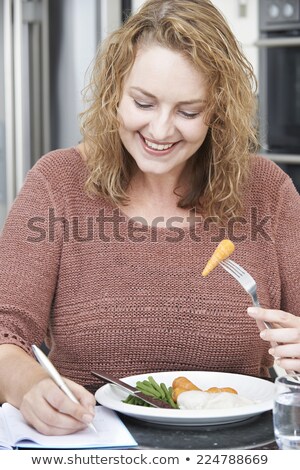 Foto d'archivio: Woman On Diet Writing Details In Food Journal