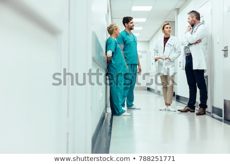 Foto stock: N · médico · y · una · enfermera · de · pie · en · un · pasillo · del · hospital