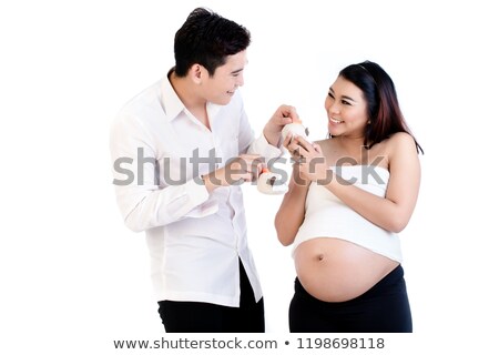 Stock photo: Happy Man And His Pregnant Wife Looking At Pair Of Baby Shoes