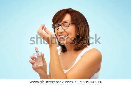 [[stock_photo]]: Senior Woman Smelling Perfume From Her Wrist