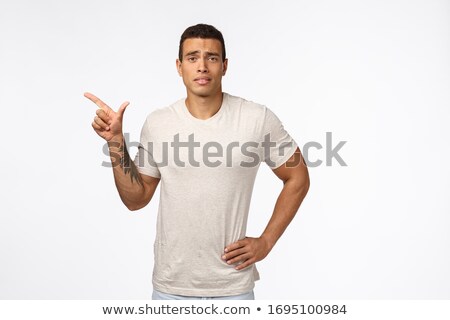Stock photo: Indecisive And Skeptical Good Looking Hispanic Guy In White T Shirt Squinting And Smirk From Dislik