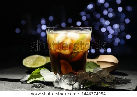 Stock foto: Glass With Cola Lime Slice And Tubule Against Blurred Lights Ba
