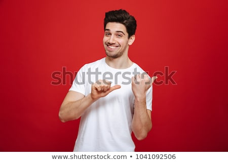 ストックフォト: Portrait Of A Happy Casual Man Pointing Fingers Away