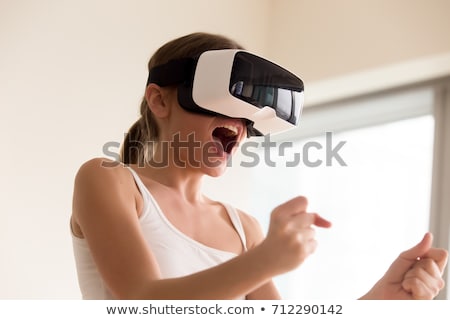 Сток-фото: Happy Young Lady Wearing Virtual Reality Device Holding Joysticks