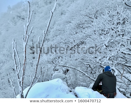 Stock fotó: Climber Belaying On Snow Covered Peak