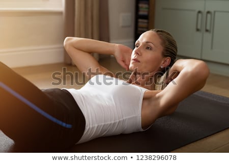 Сток-фото: Fitness Determined Middle Aged Woman Lying Doing Crunches At Home On Gym Mat
