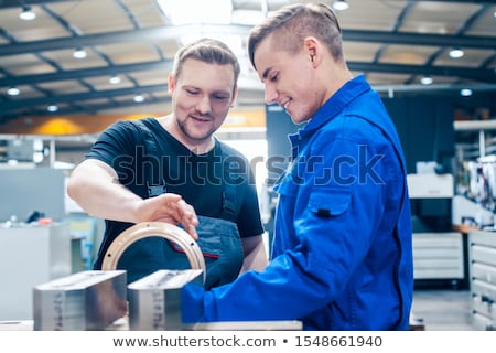 ストックフォト: Master Discussing A Workpiece With His Apprentice Or Trainee