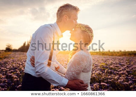 Foto stock: Bridegroom Kissing His Bride During Romantic Wedding In The Village