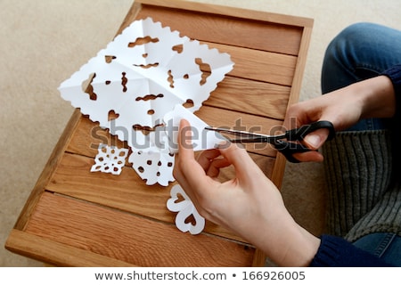 Stok fotoğraf: Using Scissors To Cut Out A Paper Snowflake Shape