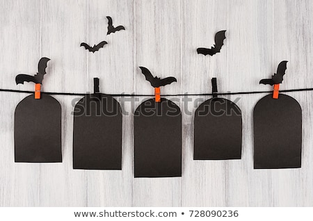 Foto stock: Halloween Flock Bats And Black Blank Labels Tomb Hanging On Clothespins On Orange Background Mock