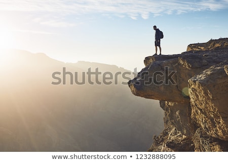 Stock fotó: Hiker On Edge Of Cliff In Sunrise