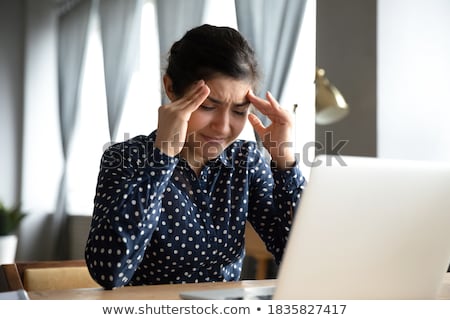 Foto stock: Woman Sitting At Desk Rubbing Temples