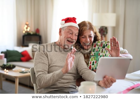 Foto d'archivio: Happy Senior Couple With Tablet Pc At Christmas