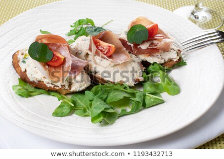 Foto stock: Bruschetta With Ricotta Prosciutto Rucola On White Plate