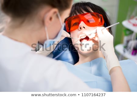 Stock photo: Close Up Of Dentist Treating Female Patient Teeth