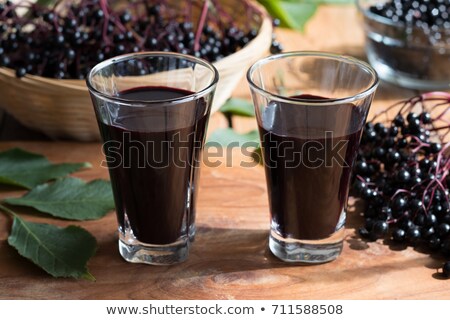 Stock fotó: Two Glasses Of Elderberry Syrup On A Wooden Background