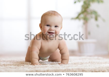 Stockfoto: Little Baby In Diaper Crawling On Floor At Home