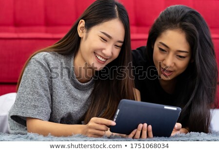 Girl Using Digital Tablet While Lying On Rug Stok fotoğraf © vichie81