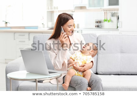 Stock foto: Working Mother With Baby Calling On Smartphone