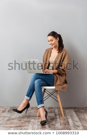 Stockfoto: Beautiful Young Girl Sits In A Chair In The Office And Holds Glasses In Her Hand