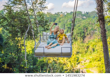 [[stock_photo]]: Young Boy Swinging In The Jungle Rainforest Of Bali Island Indonesia Swing In The Tropics Swings