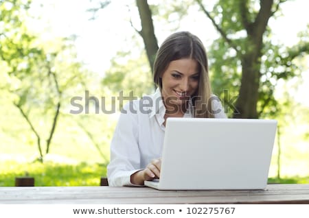 Stock photo: Beautiful Student Woman With A Laptop Sitting On Green Grass At